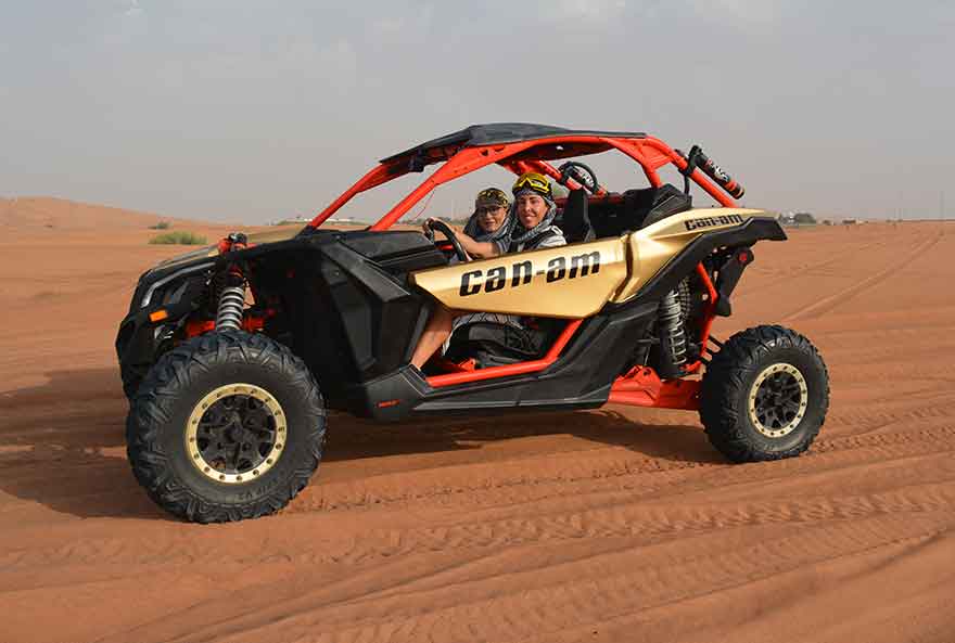 Two buddies started Can-Am Dune Buggy Tours during the daytime in a calm desert.