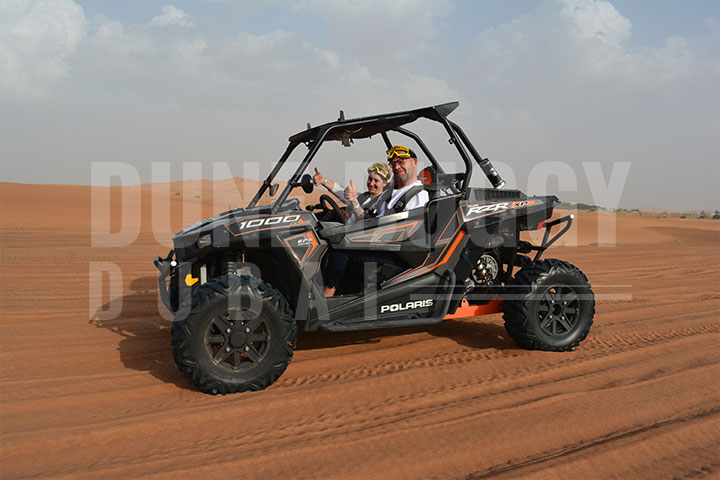 A couple enjoying a thrilling black Polaris RZR 1000 buggy ride in the desert