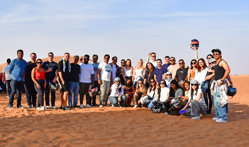 A Group of friends posing for a picture after a complete and happy desert tour in Big Red Desert, Dubai, UAE